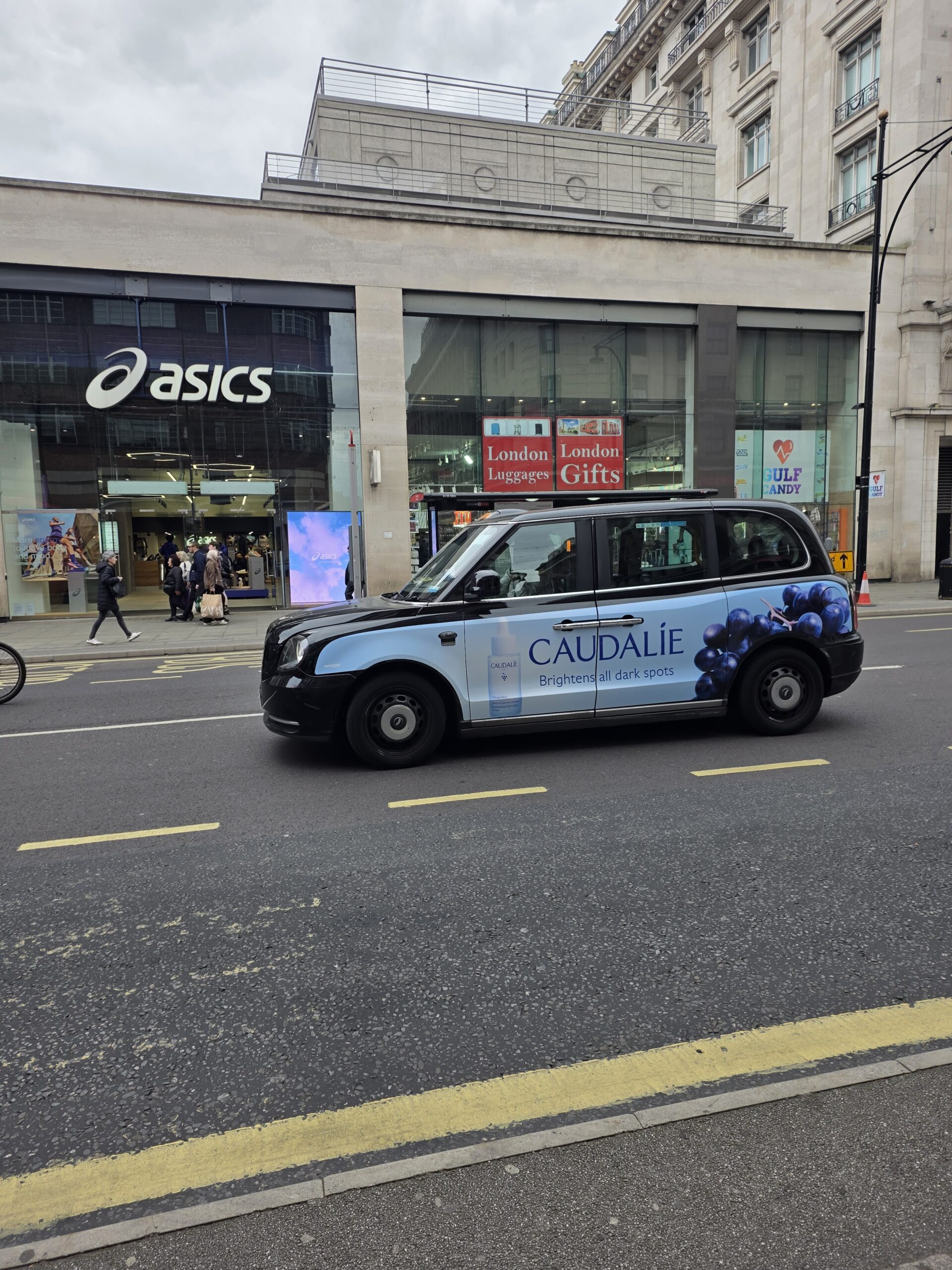 Taxi londonien arborant sur sa carrosserie une publicité pour caudalie