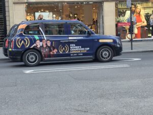 Taxi londonien arborant sur sa carrosserie une publicité pour FIFA wommen's champion cup 2026