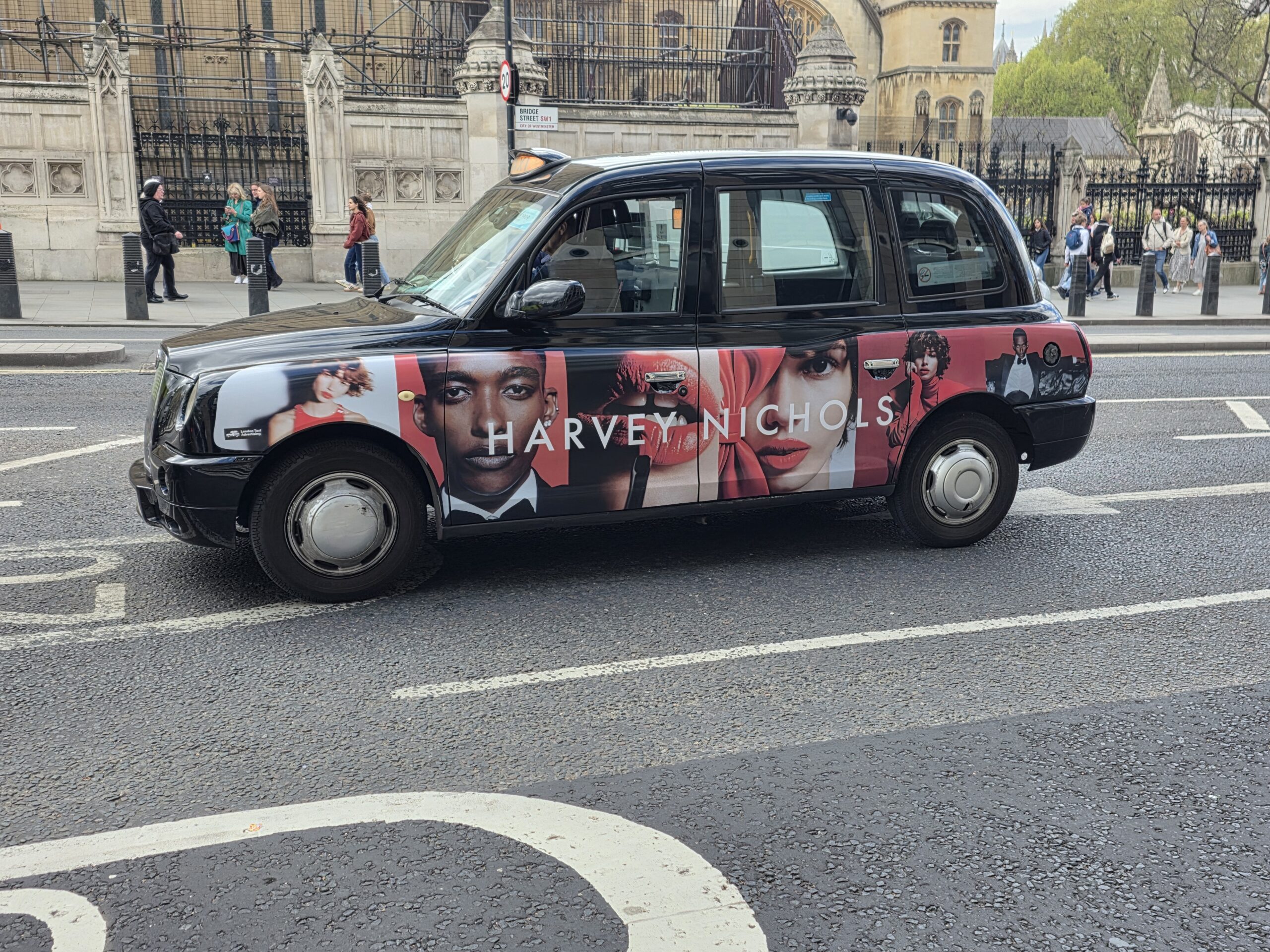 Taxi londonien arborant sur sa carrosserie une publicité pour harvey nochols