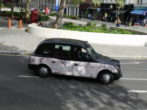 Taxi londonien arborant sur sa carrosserie une publicité pour marella