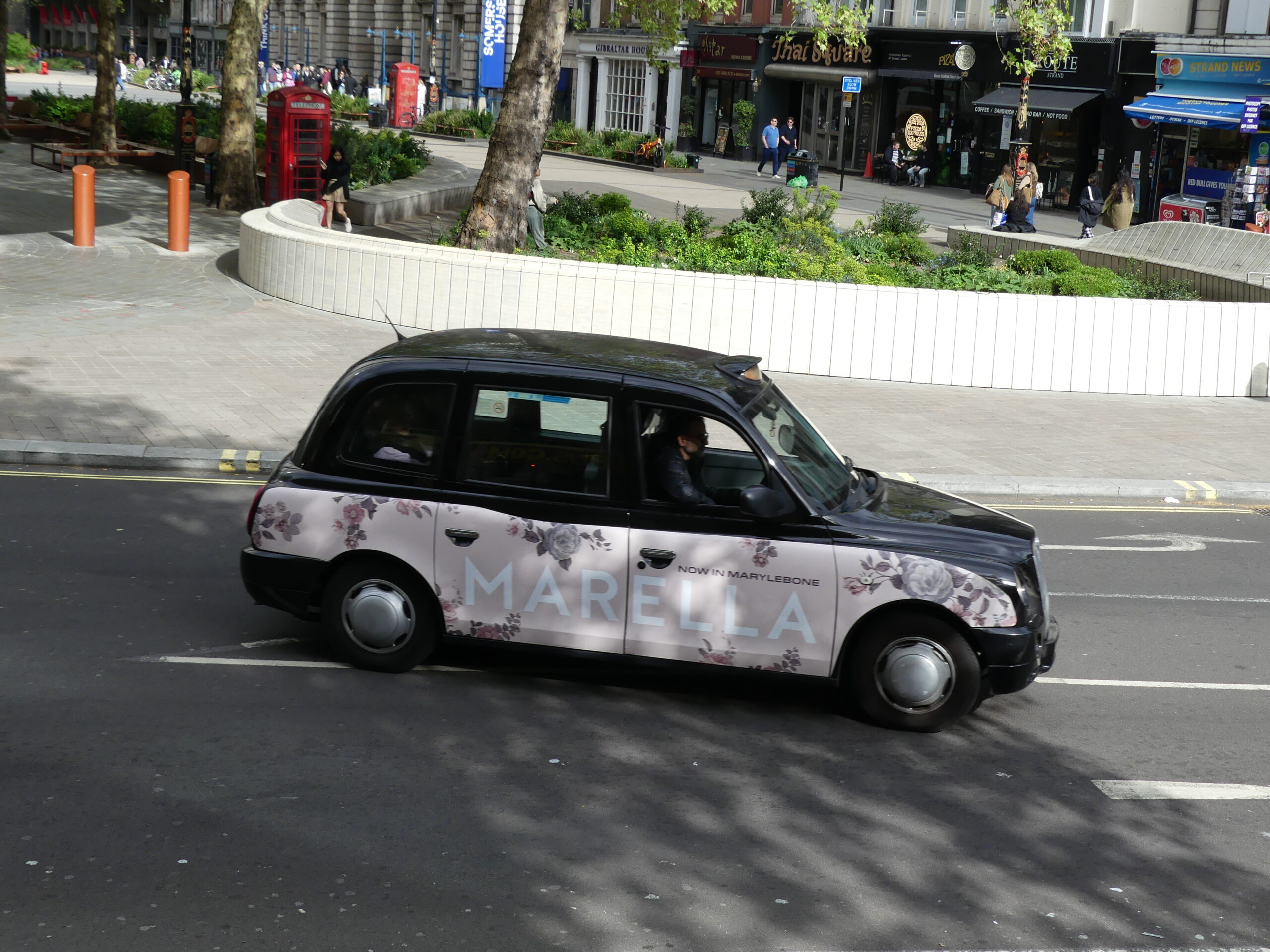 Taxi londonien arborant sur sa carrosserie une publicité pour marella