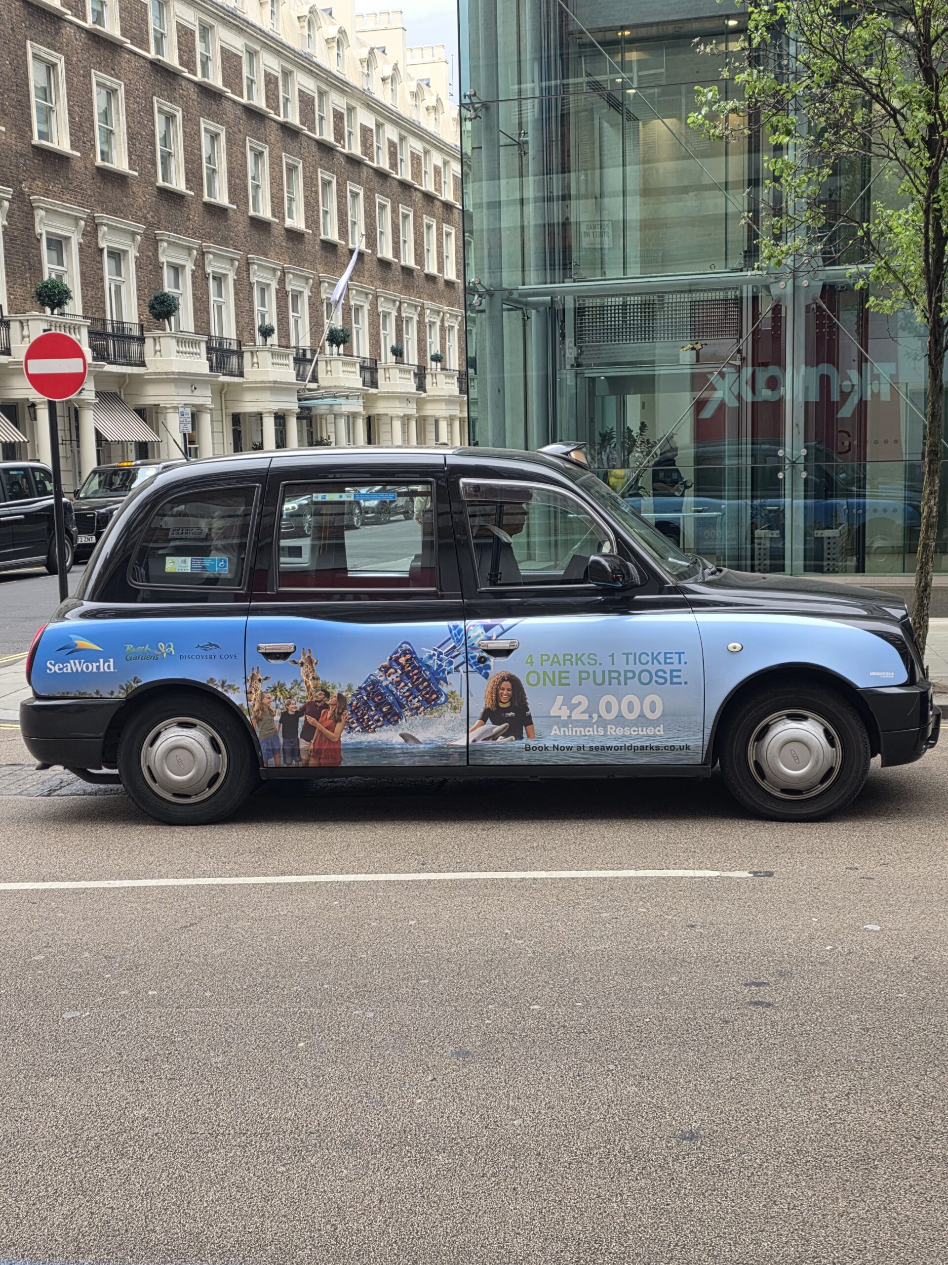 Taxi londonien arborant sur sa carrosserie une publicité pour cine purpose