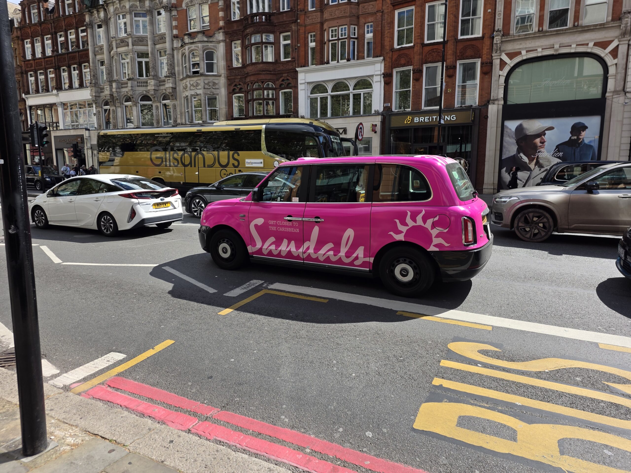 Taxi londonien arborant sur sa carrosserie une publicité pour sandals