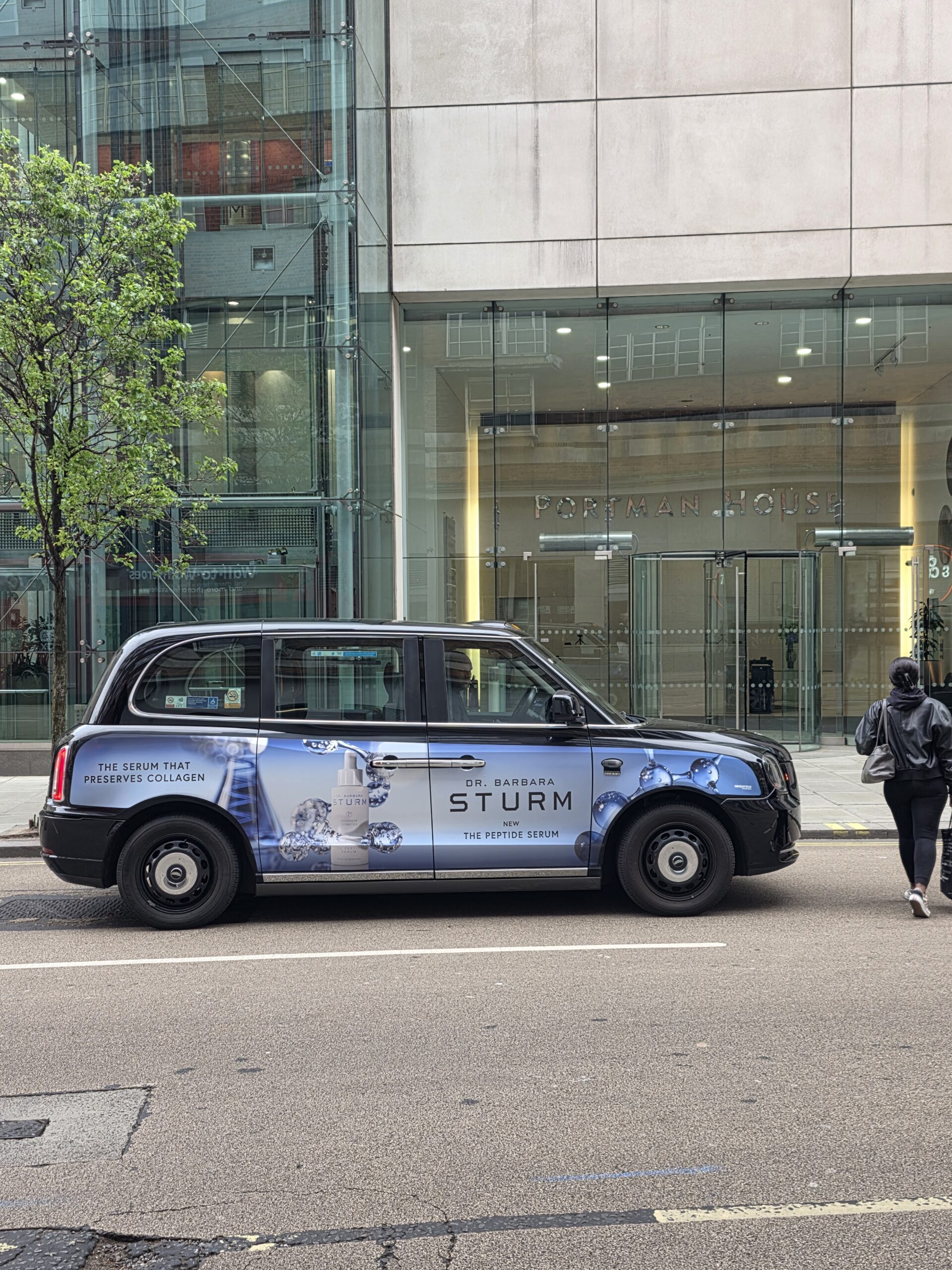 Taxi londonien arborant sur sa carrosserie une publicité pour sturm
