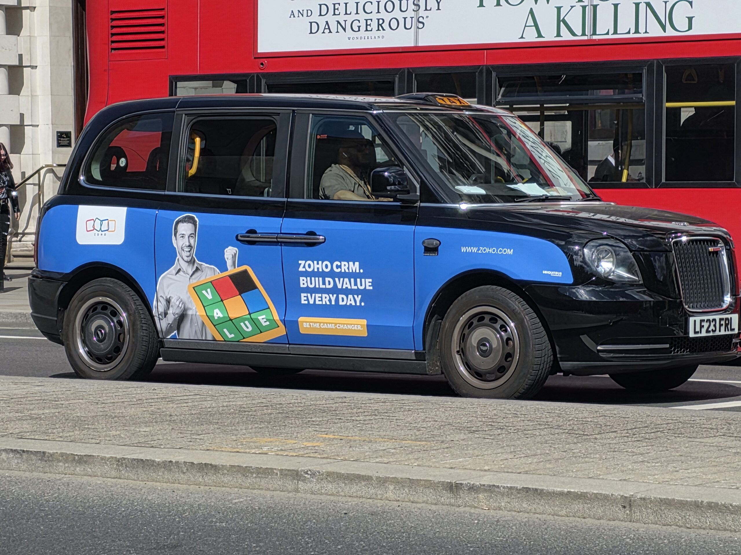 Taxi londonien arborant sur sa carrosserie une publicité pour zoho crm