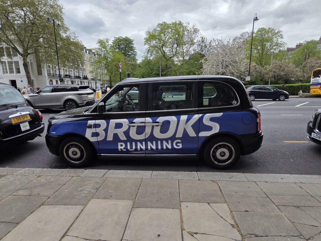 Taxi londonien arborant sur sa carrosserie une publicité pour brooks