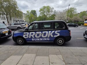 Taxi londonien arborant sur sa carrosserie une publicité pour brooks